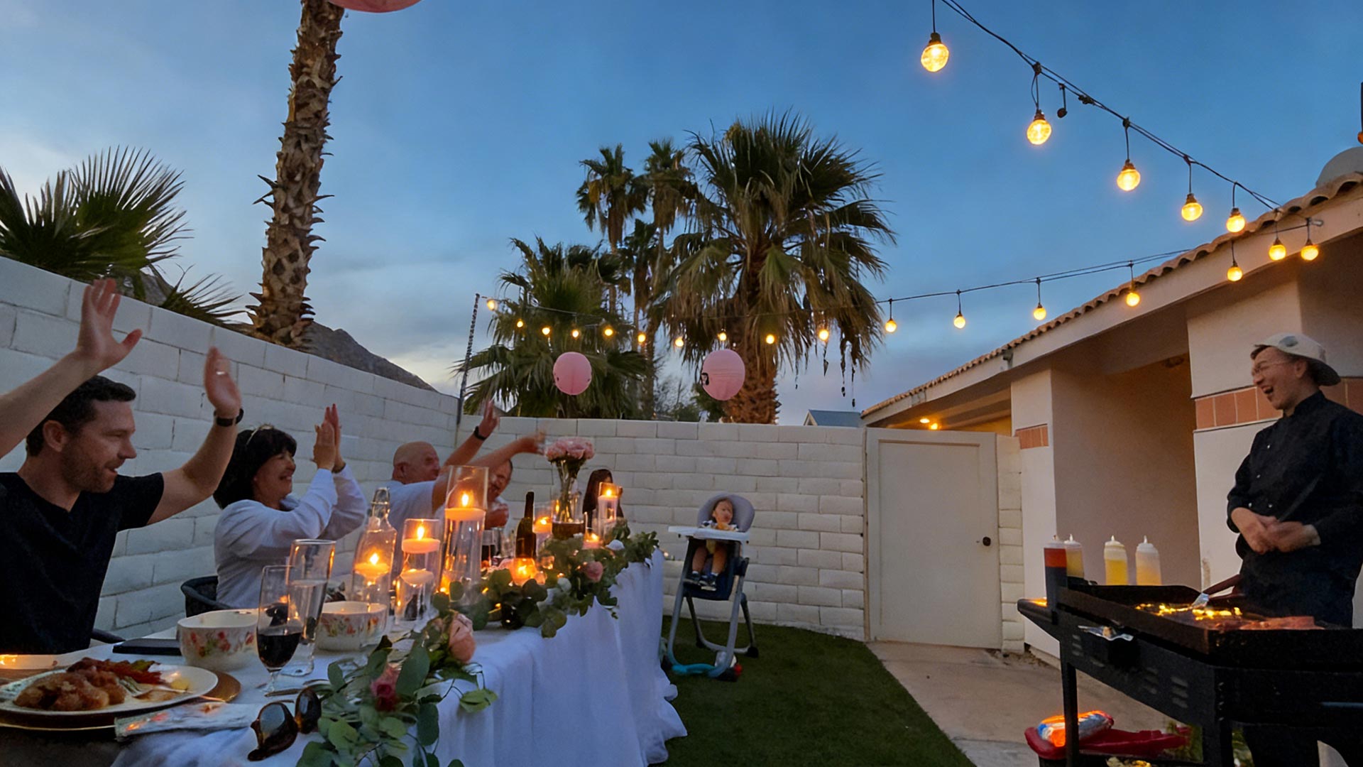 Guests cheering during an interactive backyard hibachi party in a private outdoor setting.